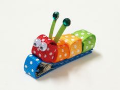 a small toy made to look like a caterpillar with polka dots on it