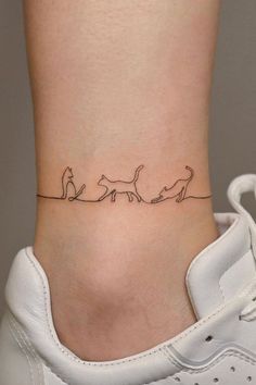 a woman's ankle with three cats on it and one cat running behind the other