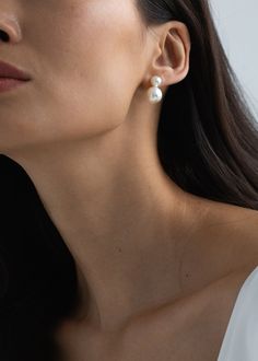 a woman wearing earrings with pearls on her ear