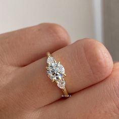 a woman's hand holding a diamond ring