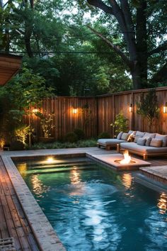 a small pool with lights around it and some couches in the water next to it