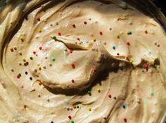 a cake with white frosting and sprinkles on it in a pan