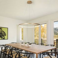 a dining room table with chairs and a large painting on the wall in front of it