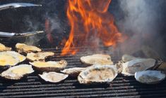 oysters being cooked on the grill with flames