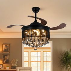 a living room with a ceiling fan and chandelier in the middle of it