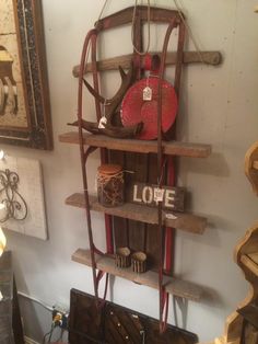 a wooden shelf with various items on it in a room that has pictures and other decor