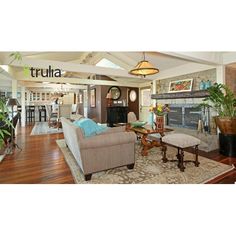 a living room filled with furniture and a fire place in the middle of an open floor plan