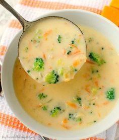 a spoonful of broccoli cheese soup with carrots and celery