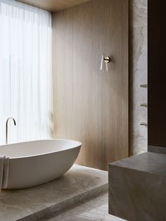 a large white bath tub sitting next to a window