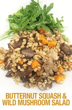 a white plate topped with brown rice and veggies next to green leafy garnish