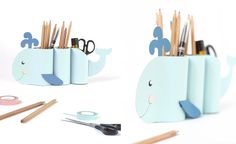 pencils, scissors and other office supplies are arranged in the shape of a whale