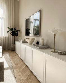 a living room filled with furniture and a flat screen tv mounted on a wall above it