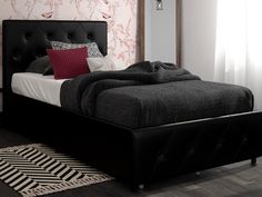 a bed with black headboard and foot board next to a wallpapered bedroom