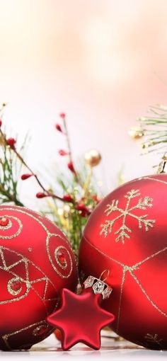 two red christmas ornaments sitting next to each other