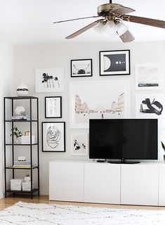 a flat screen tv sitting on top of a white entertainment center in a living room