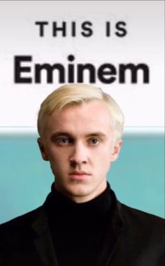 a man with blonde hair standing in front of a sign that says, this is emiem