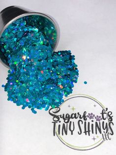 blue and green glitter in a metal container on a white background with the words sugar & tiny shinys