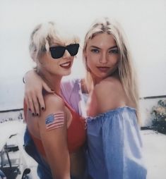 two women with american flag tattoos on their arms posing for a photo in the snow