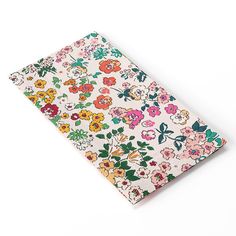 a notebook covered in colorful flowers on a white background