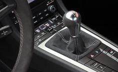 the interior of a car with a steering wheel and control knob on it's center console