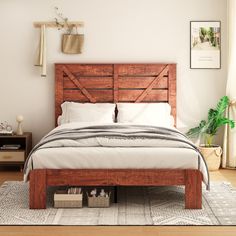 a bed with wooden headboard and foot board in a white room next to a window