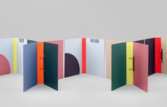 an assortment of colored folders are arranged in a row on a gray background with one opened