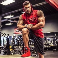 a man squatting on a bench in a gym