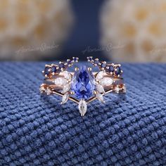 a tan and blue ring sitting on top of a blue blanket next to a pillow