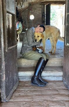 a man sitting on the steps with his dog next to him and holding a camera