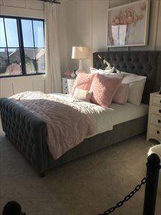 a bedroom with a bed, dressers and window in it's center area