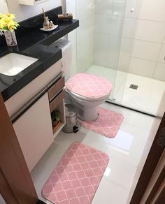 a bathroom with pink rugs on the floor