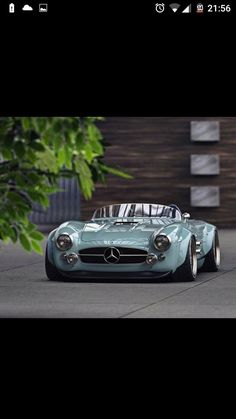 an old blue sports car is parked on the street