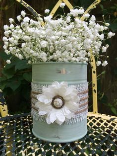 white flowers are in a blue bucket on a table