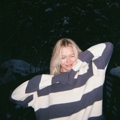 a woman with blonde hair wearing a striped sweater