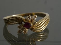 This beautiful Vintage late 1970's - early 1980's split semi bypass Ruby and Diamond ring is the perfect birthday gift for July or anyone who loves Rubies. Item Specifics Weight: 2 Grams Metal: 14k Yellow Gold Stones: .08 ct Natural Ruby, 6 .025ct Natural Diamonds The table of the top stone sits 4.57mm above the finger Ruby Ring Vintage Gold, 60s Engagement Ring, Classic Unique Engagement Ring, Vintage Rings Antiques, Engagement Ring Thick Band, Vintage Ruby Ring, Ruby Engagement Ring Vintage, Vintage Gold Ring, Vintage Jewelry Antique