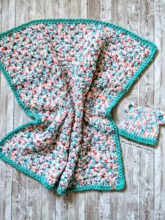 a crocheted blanket and matching hat on a wooden surface