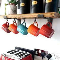 coffee cups are hanging on the kitchen wall