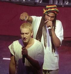 two men standing next to each other holding microphones