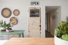 an open door sits in the middle of a room with several plates on the wall