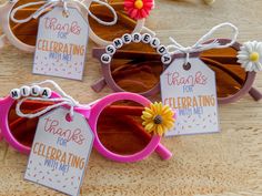 three pairs of pink sunglasses with thank you for celebrating with me tags attached to them