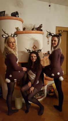 three women dressed in reindeer costumes posing for the camera with their hands on their hipss