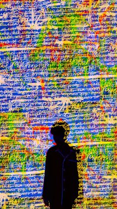 a man standing in front of a colorful wall