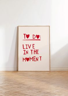 a poster with the words to do live in the moment on it next to a wooden floor