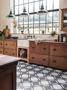 a kitchen with wooden cabinets and black and white checkered flooring on the floor