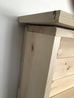 a wooden shelf sitting on top of a white wall