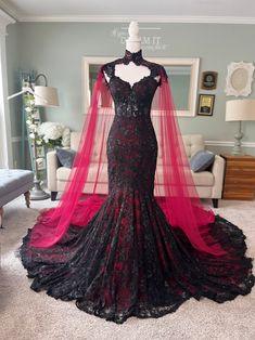 a black and red wedding dress on display in a room with white carpeted flooring