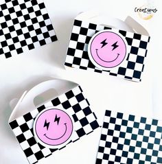 three black and white checkered boxes with pink smiley faces on them, one has a lightning bolt in the middle