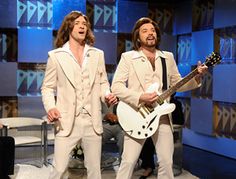 two men in white suits are playing guitars