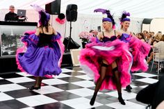 two women dressed in pink and purple dancing on a checkered floor