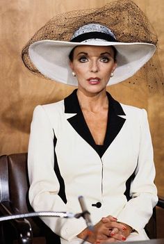 a woman wearing a hat sitting at a desk